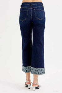 Blue jeans with patterned cuffs on a white background