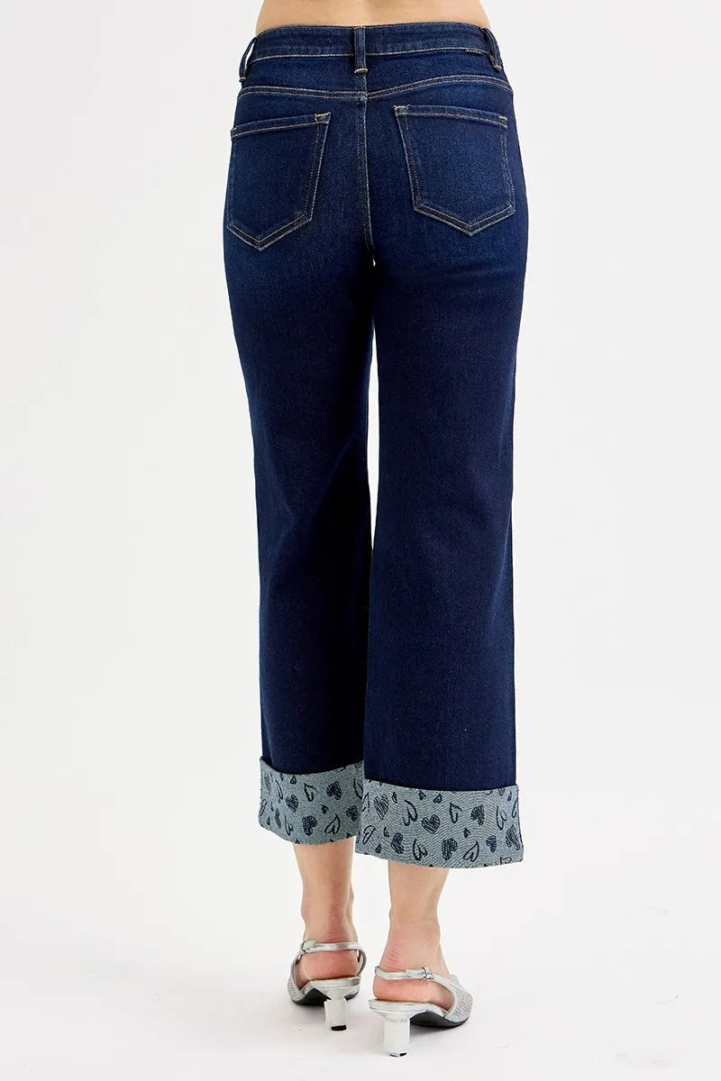 Blue jeans with patterned cuffs on a white background