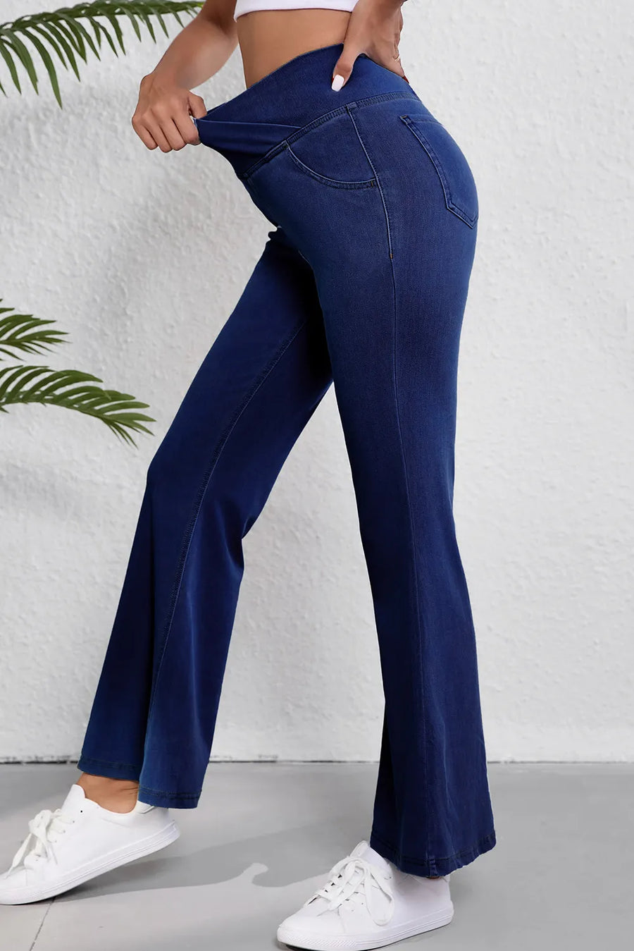 Person wearing blue flared jeans with a white background