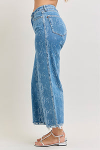Blue acid-wash jeans worn by a person on a white background