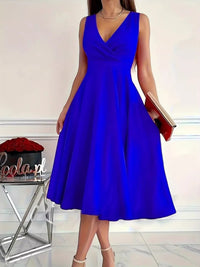 Woman wearing a blue dress holding a red book with a blurred background
