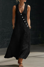 Woman wearing a black sleeveless dress with buttons against a dark background