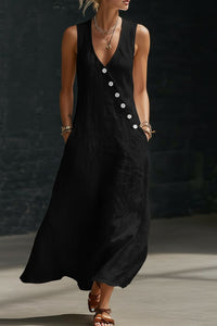 Woman wearing a black sleeveless dress with buttons against a dark background