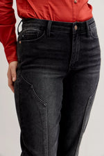 Person wearing black jeans and a red shirt on a light gray background