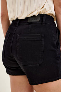 Black shorts worn by a person with a neutral background