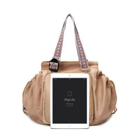 Beige handbag with a patterned strap holding an iPad Air on a white background