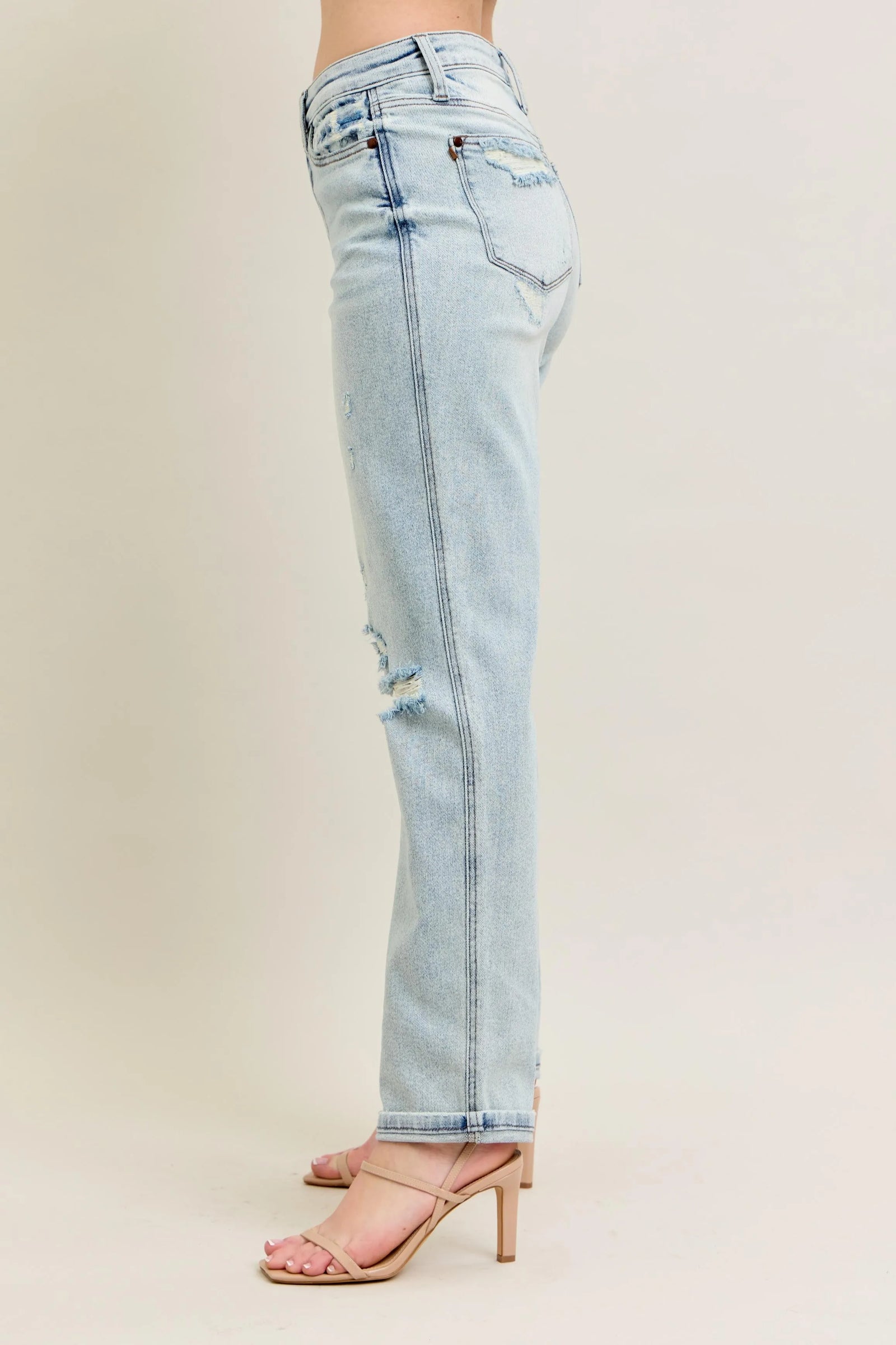 Light blue jeans with a distressed design on a beige background
