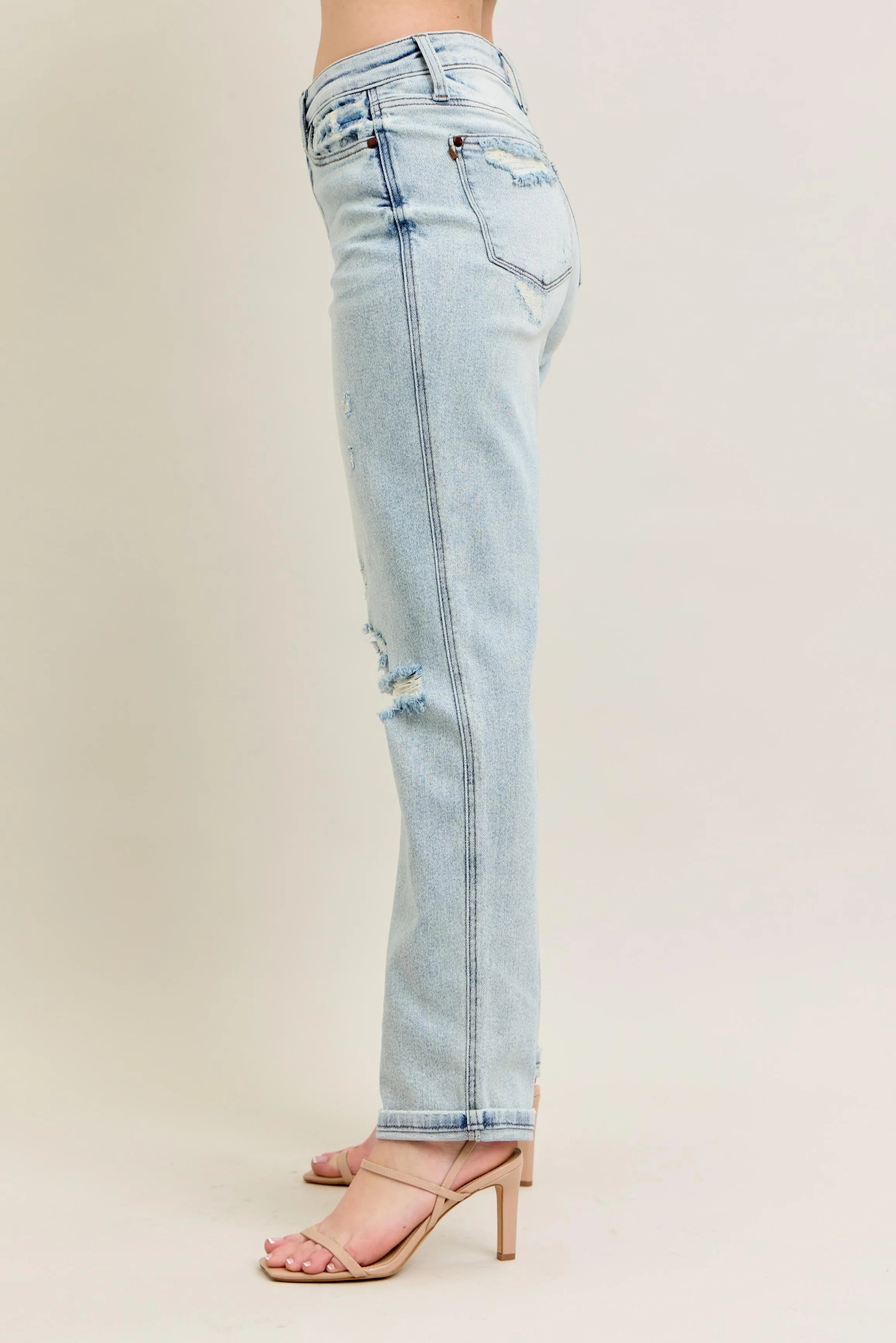 Light blue jeans with a distressed design on a beige background
