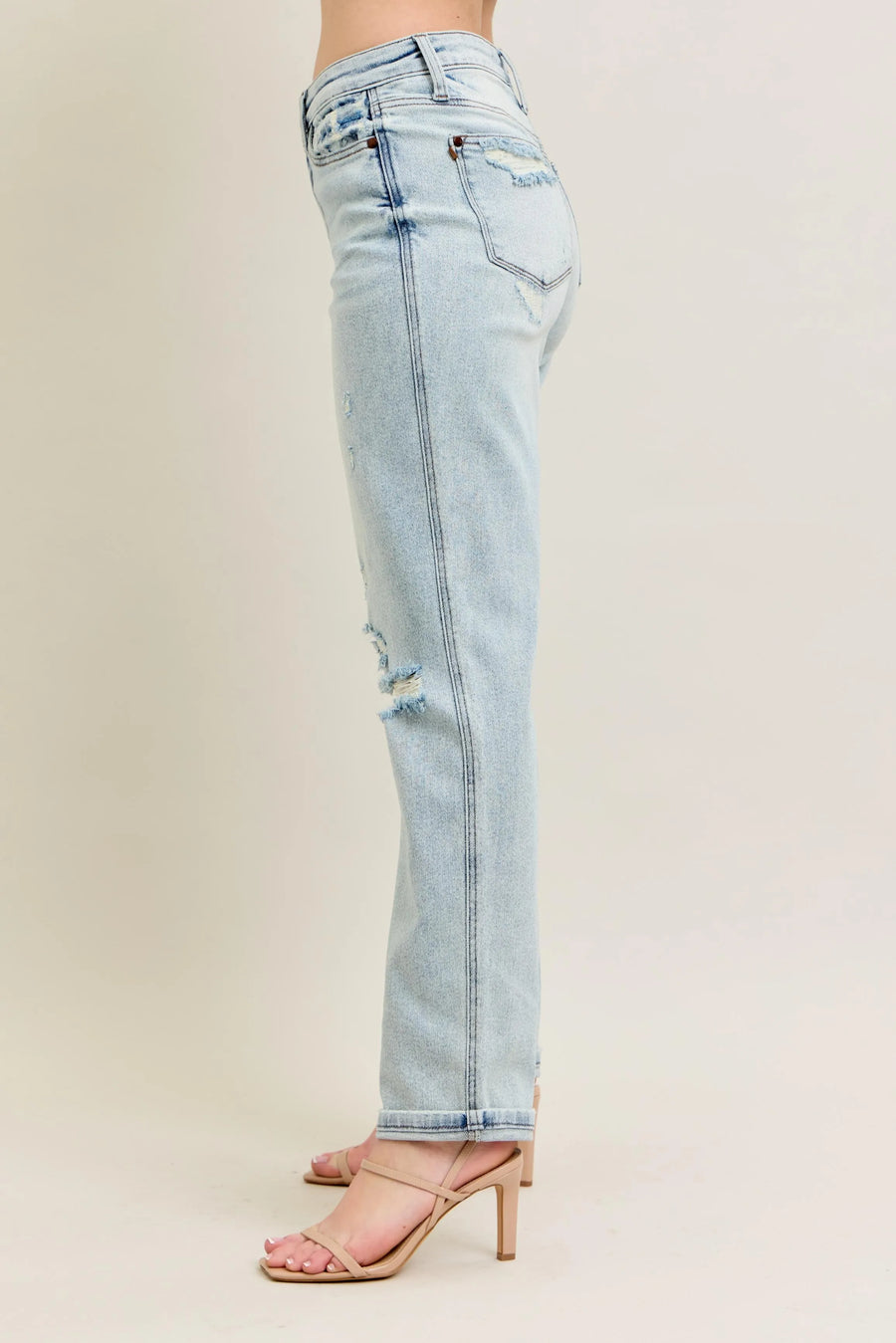 Light blue jeans with a distressed design on a beige background