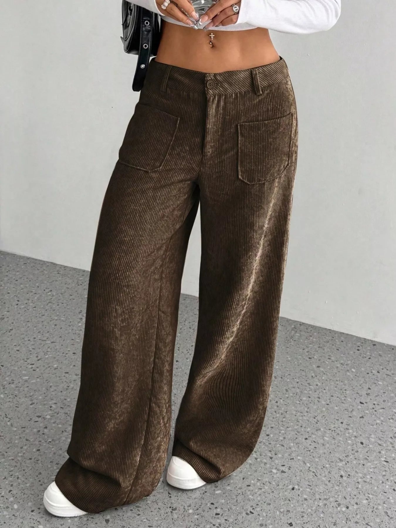 Brown corduroy wide-leg pants worn by a person on a gray floor.