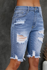 Ripped blue denim shorts on a dark background