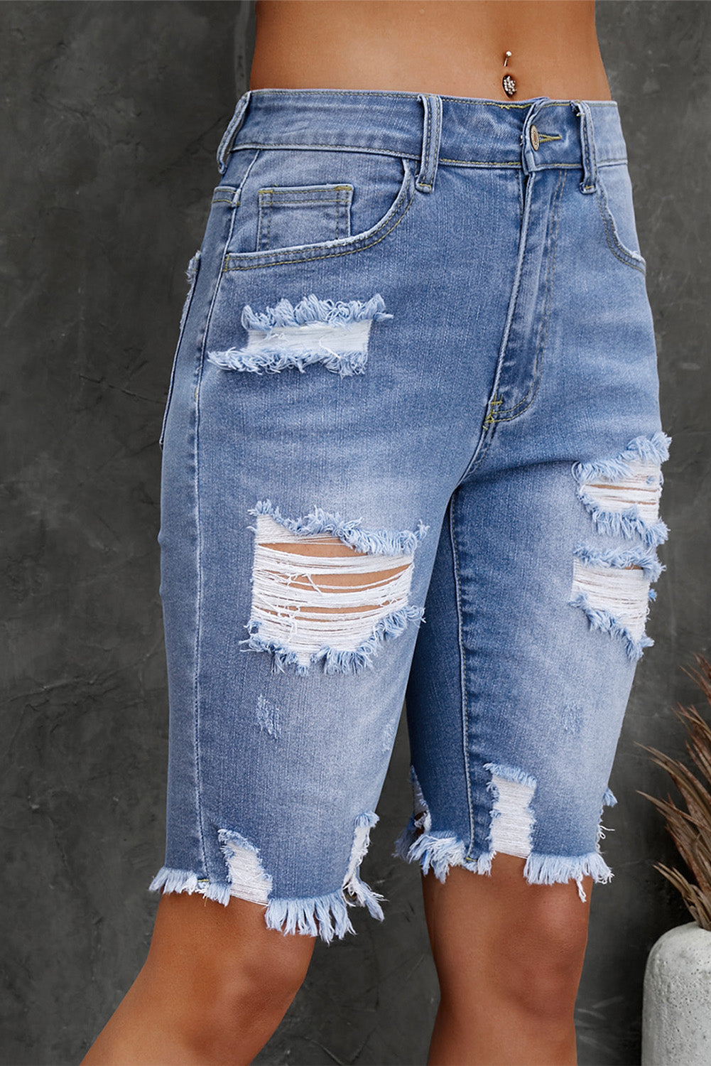 Ripped blue denim shorts on a dark background