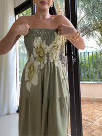 Woman wearing a green floral dress indoors with a window in the background