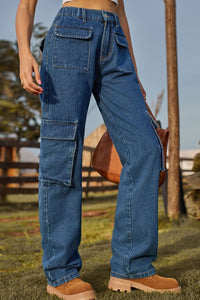 Person wearing blue cargo jeans with a blurred outdoor background