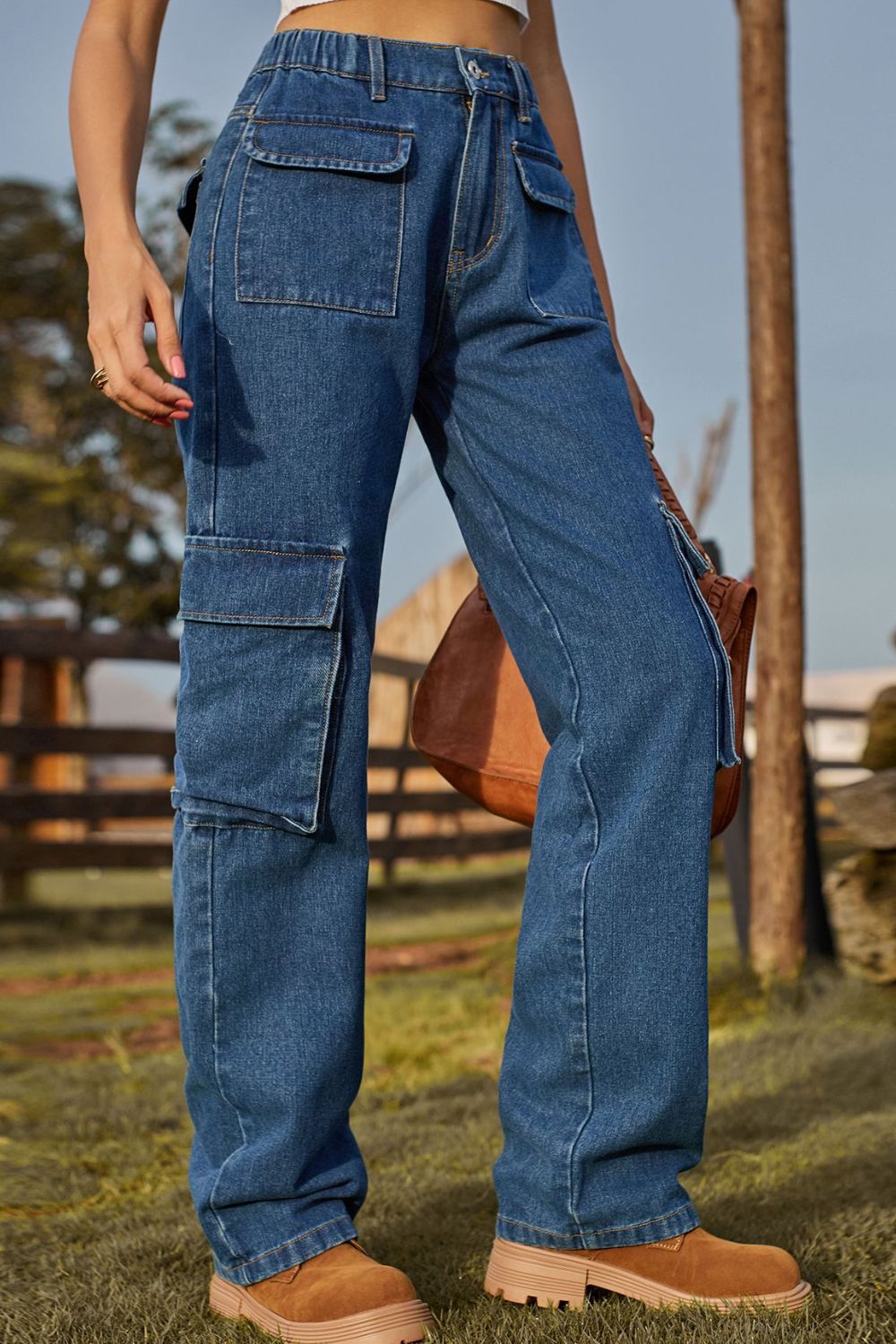 Person wearing blue cargo jeans with a blurred outdoor background