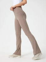 Beige flared pants worn by a person on a white background