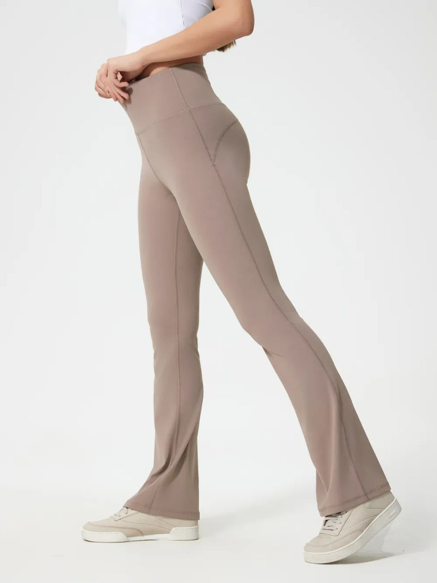 Beige flared pants worn by a person on a white background