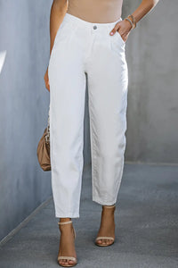Person wearing white pants with a neutral background
