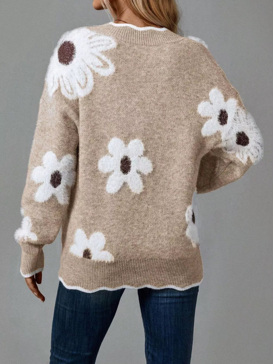 Beige sweater with white floral patterns on a gray background