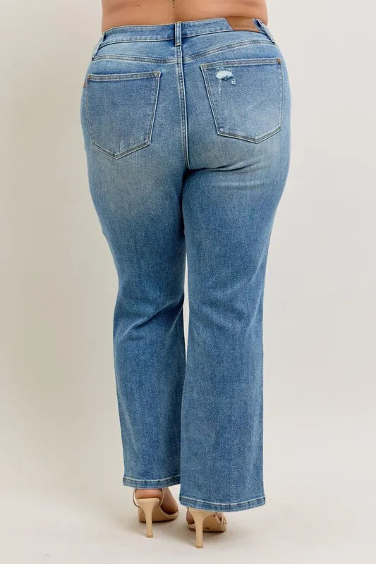 Blue jeans worn by a person on a plain background