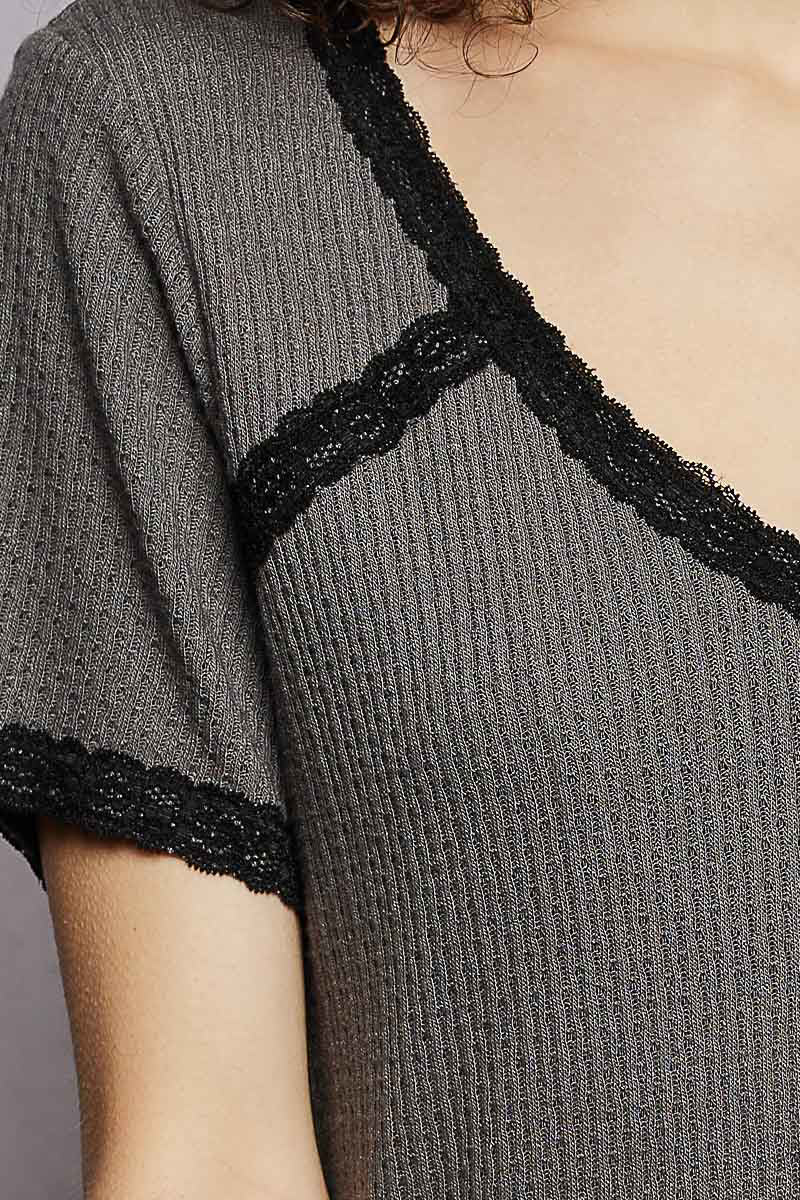 Gray ribbed dress with black lace trim on a neutral background