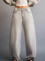 Person wearing light gray high-waisted jeans on a plain background