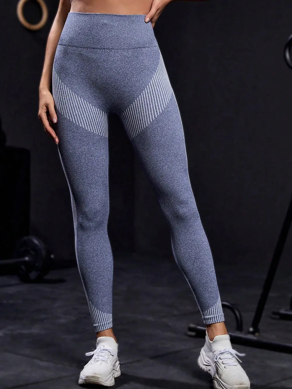Person wearing blue athletic leggings on a black background