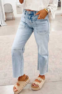 Person wearing light blue jeans and beige sandals indoors.