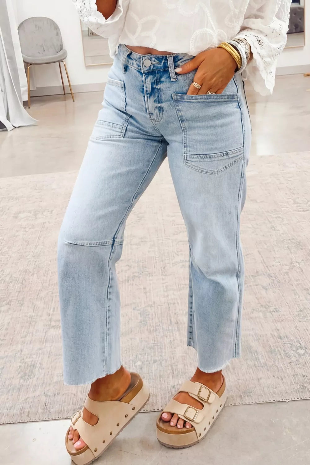 Person wearing light blue jeans and beige sandals indoors.