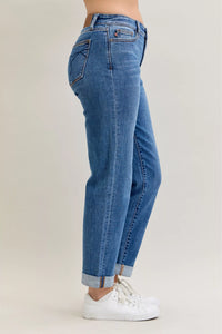 Blue jeans worn by a person on a plain background