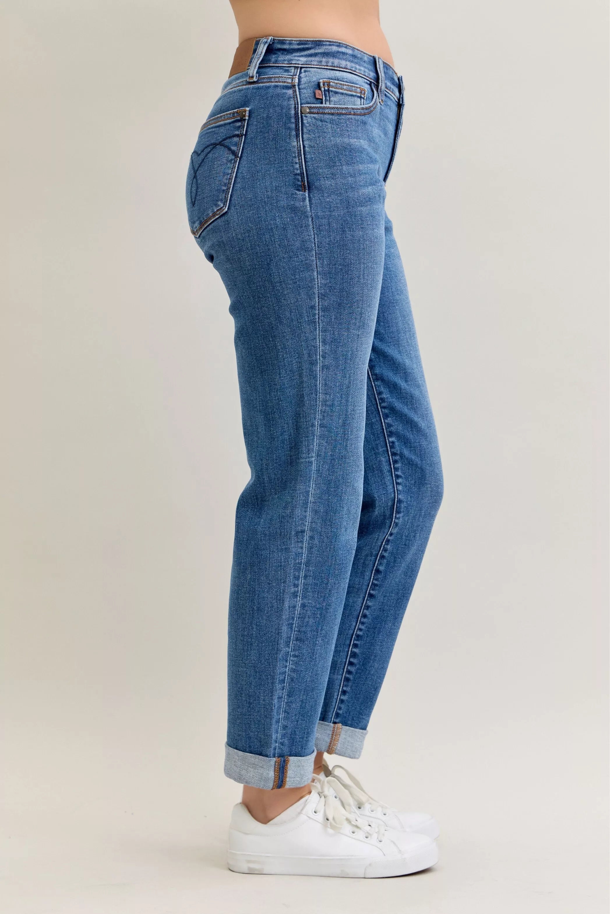 Blue jeans worn by a person on a plain background