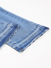 Close-up of a blue denim fabric with frayed edges on a white background