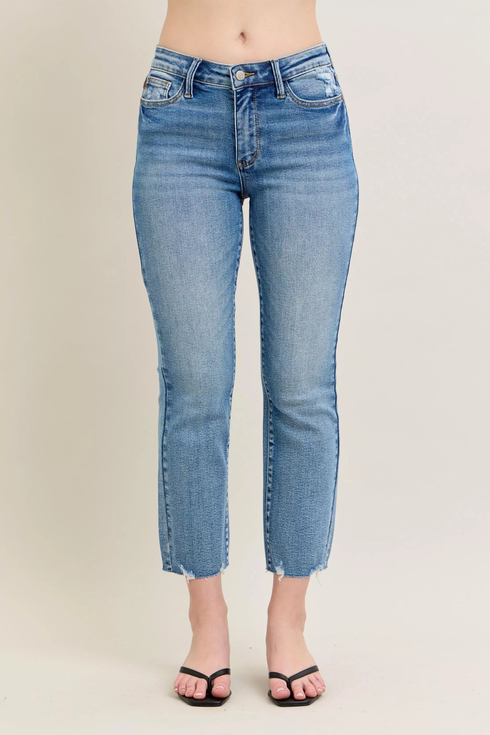 Light blue jeans worn by a person on a beige background