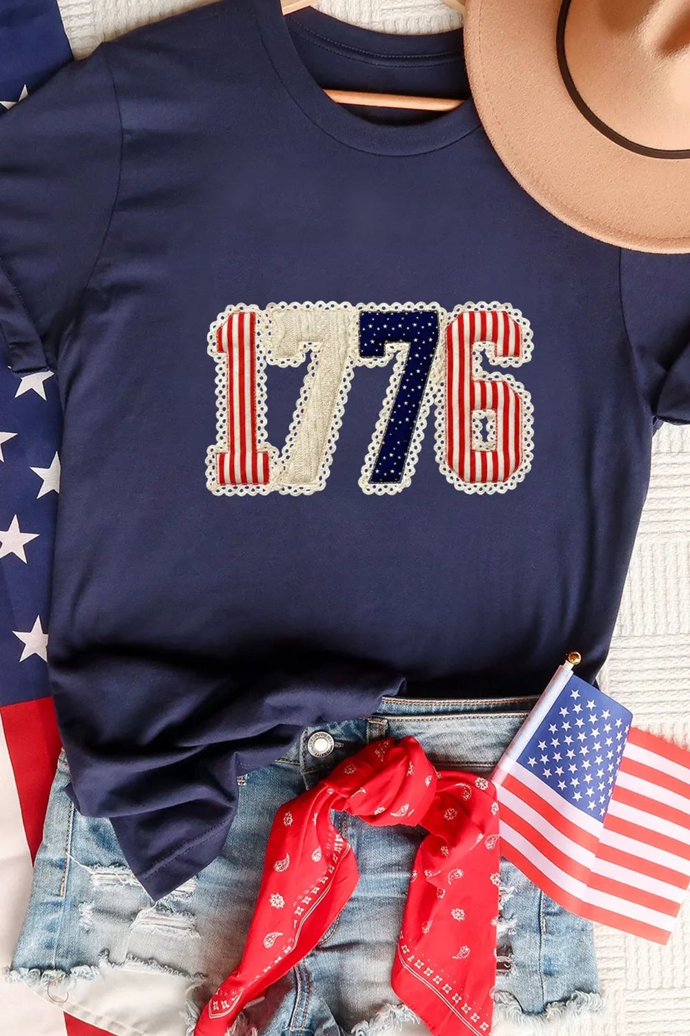 Navy blue sweatshirt with '1776' design, American flags, and denim jeans.
