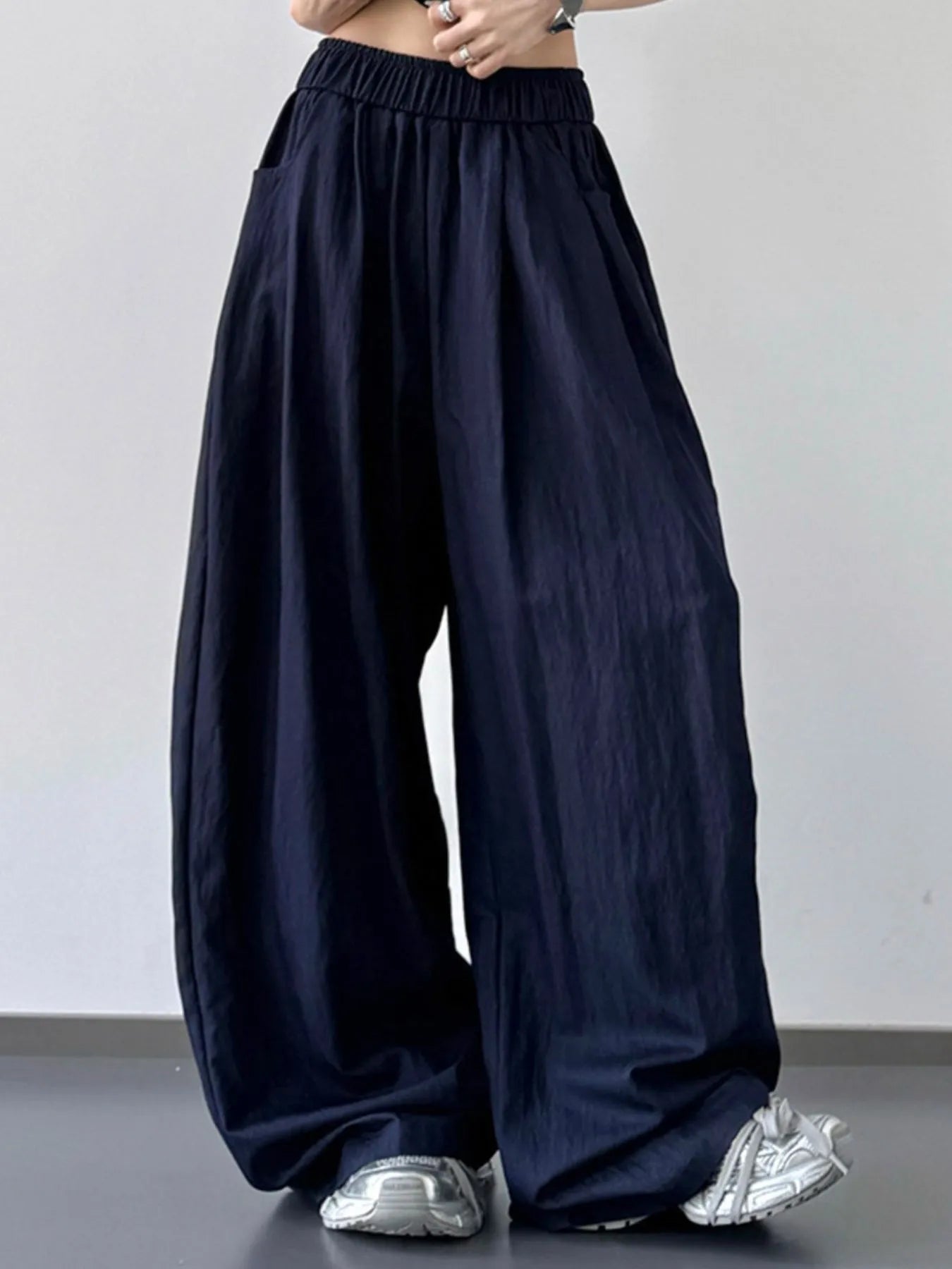 Navy blue wide-leg pants worn by a person on a plain background