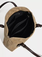 Open beige backpack with black interior on a white background