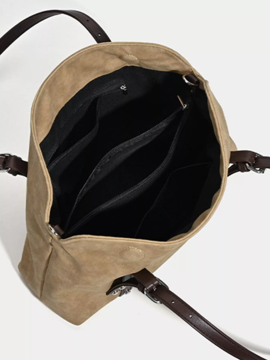 Open beige backpack with black interior on a white background