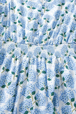 Close-up of a blue floral patterned fabric with green leaves on a white background