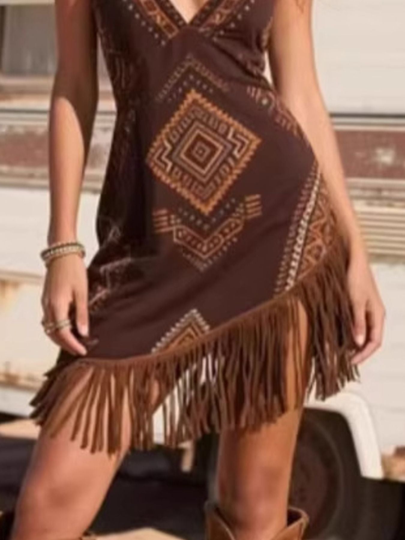 Brown patterned dress with fringe details worn by a person.