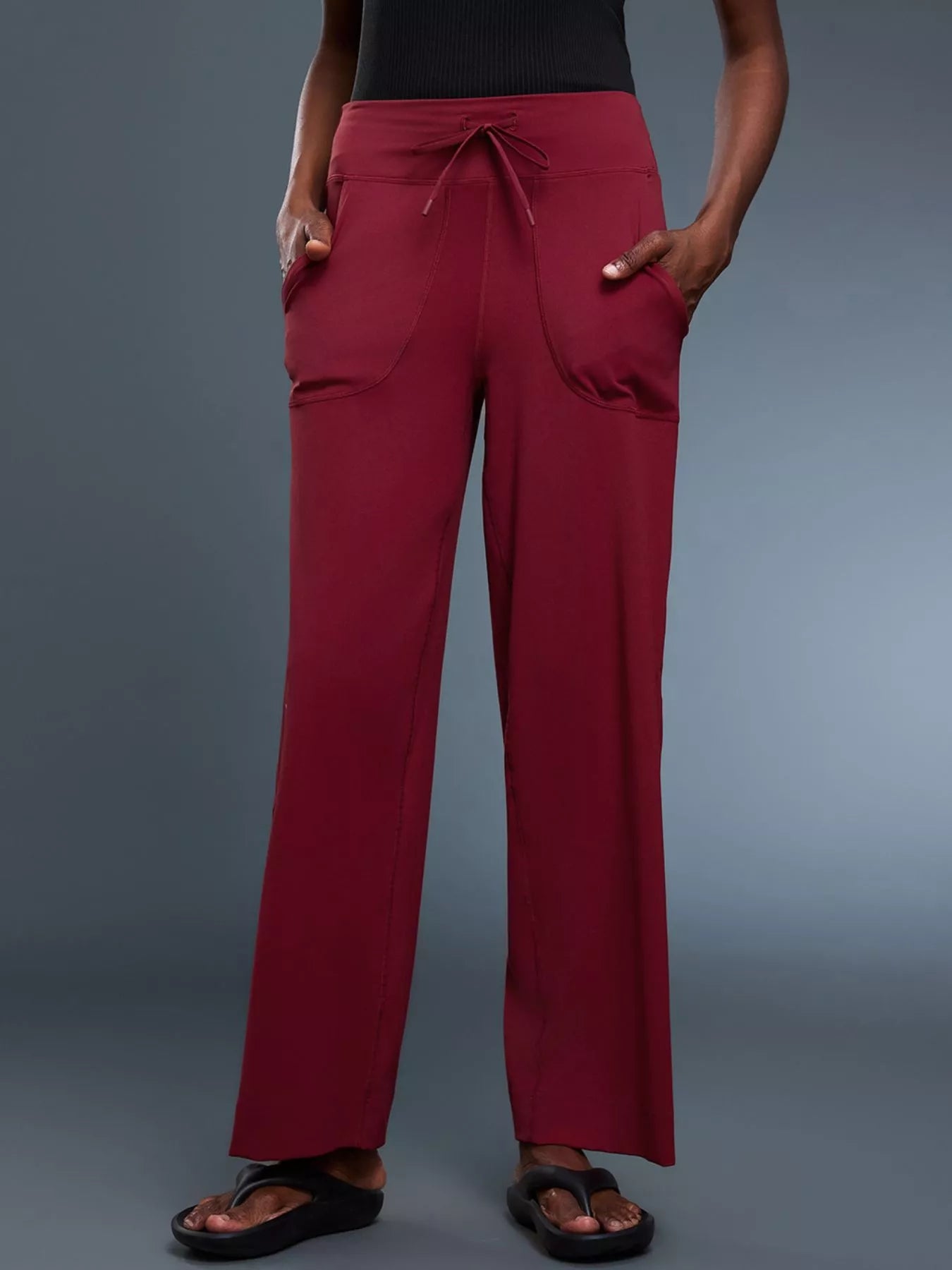 Red pants worn by a person on a gray background