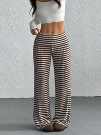 Person wearing brown and white checkered pants against a plain background