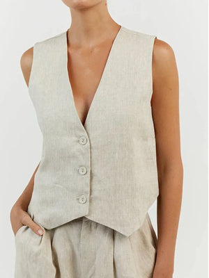 Person wearing a beige vest and pants on a white background