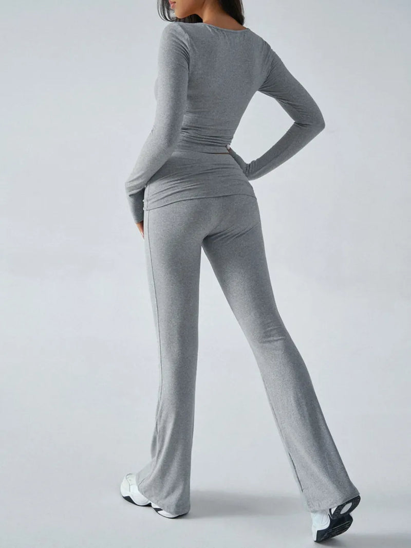 Person wearing a gray long-sleeve top and pants set on a white background