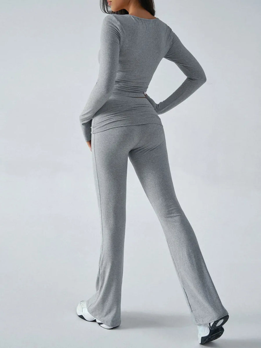 Person wearing a gray long-sleeve top and pants set on a white background