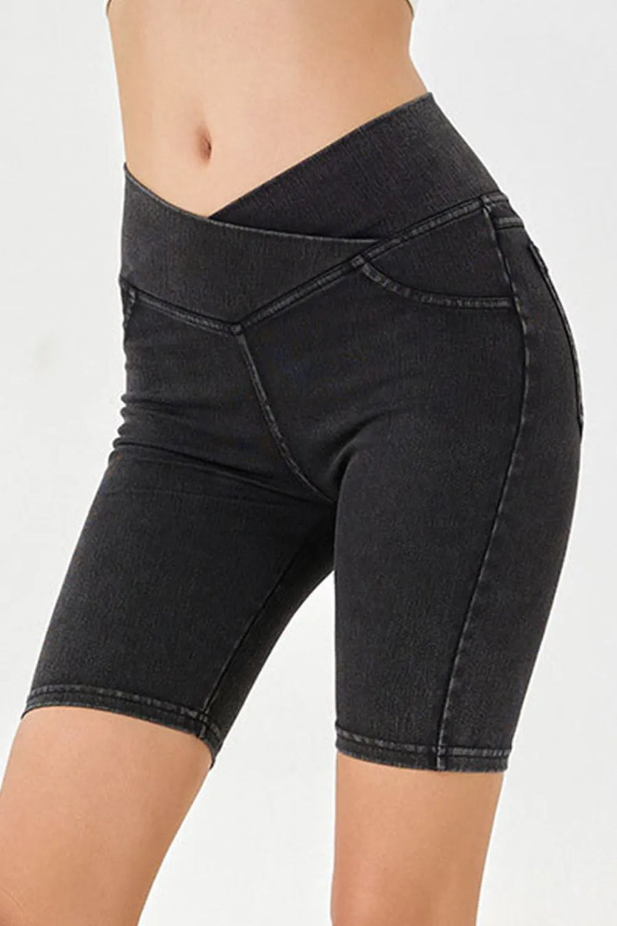 Black denim shorts worn by a person on a white background