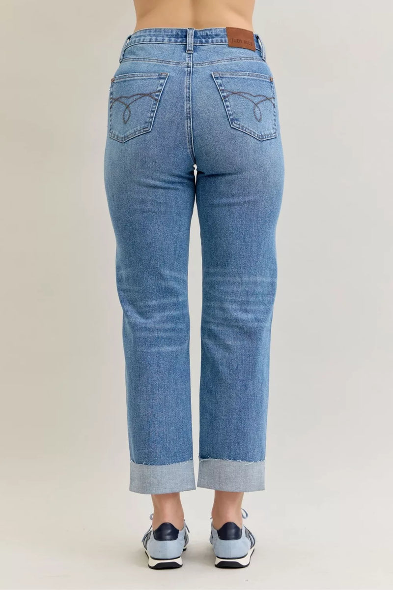 Blue jeans worn by a person on a beige background