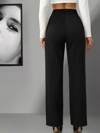 Person wearing black wide-leg pants with a white cropped top against a gray background.