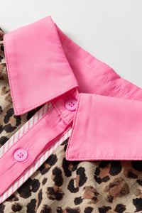 Close-up of a pink shirt collar with buttons on a leopard print fabric background