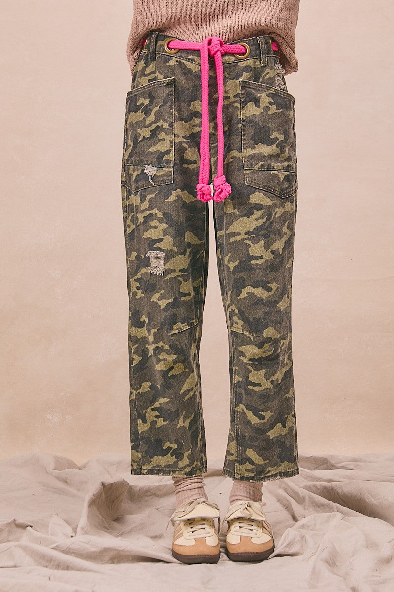 Camouflage pants with pink drawstring on a neutral background