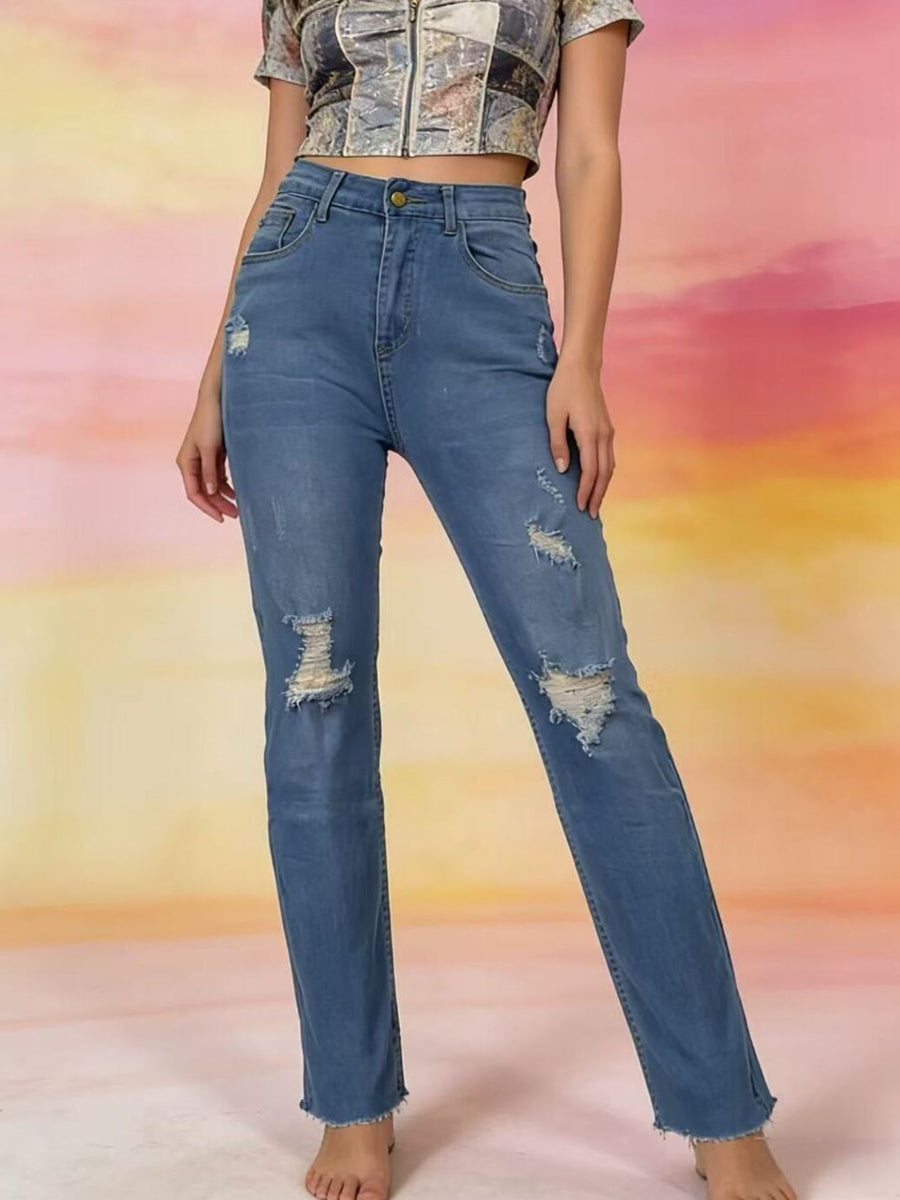 Person wearing blue jeans with a colorful abstract background